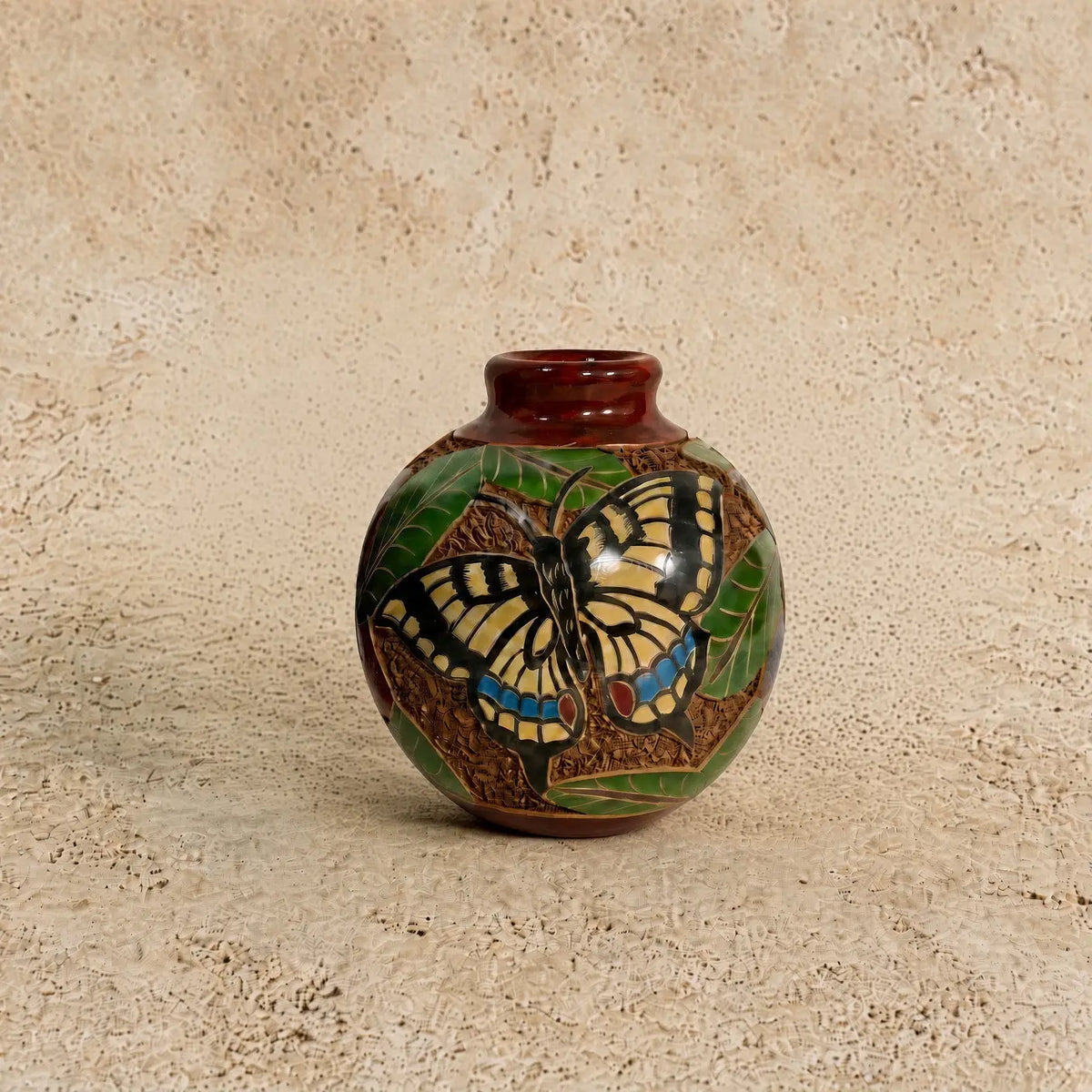 Mini carved clay vase with glossy brown glaze featuring intricate hand carvings of a yellow butterfly and green leaves