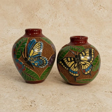 Mini carved clay vase with intricate hand carvings of blue and yellow butterflies on green leaves and glossy brown glaze