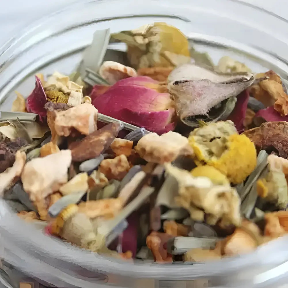 A clear glass jar filled with colorful dried herbs flowers and fruit pieces for a mood-boosting simmer pot blend