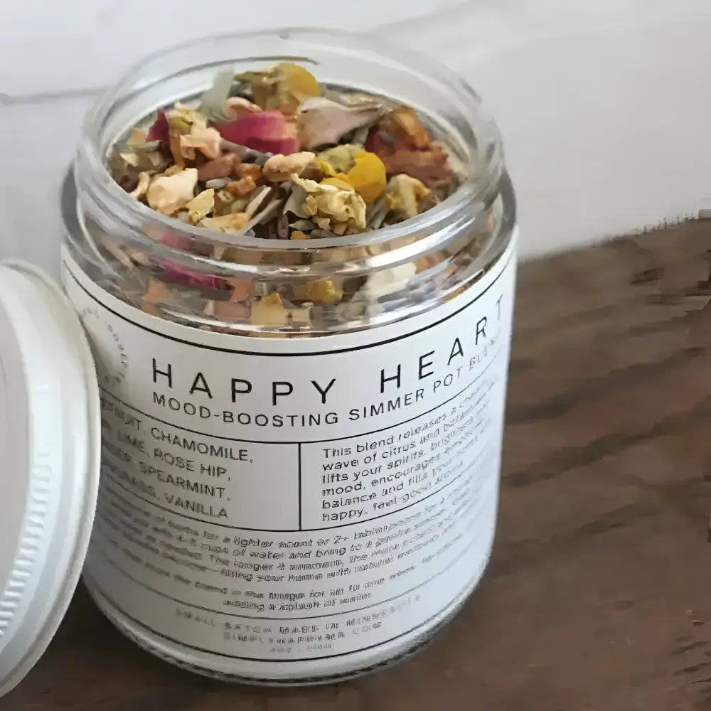 A clear glass jar filled with a colorful happy heart mood-boosting simmer pot blend of dried herbs and flowers