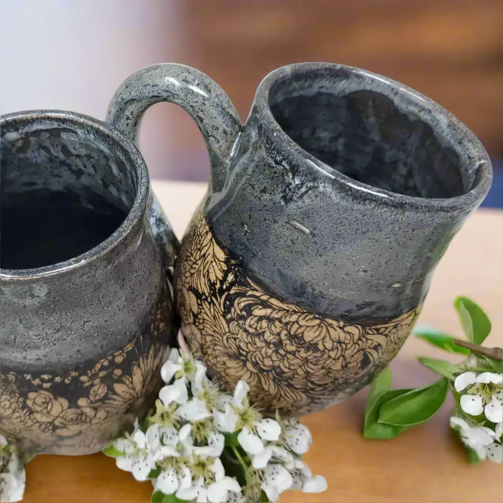 Handmade floral mug with dark grey glaze and intricate unglazed flower patterns