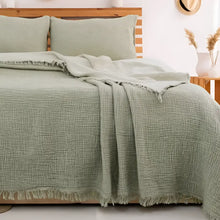 Bedroom with a green checkered blanket on a wooden bed, hats on the wall.