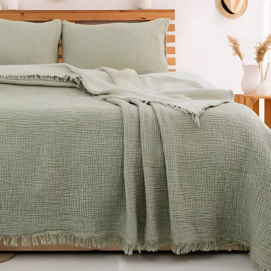 Bedroom with a green checkered blanket on a wooden bed, hats on the wall.