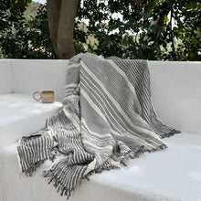 Striped gray and cream blanket on a light surface