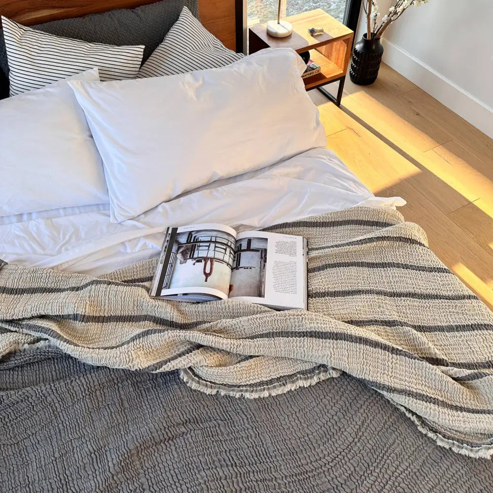 Charcoal gray and cream colored reversible striped muslin blanket for king or queen sized beds.