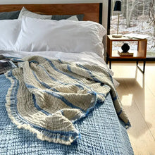 Blue and cream colored reversible striped muslin king or queen sized bed blanket.