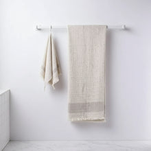 Textured off-white linen towels hanging on copper rod, perfect as double-layered muslin bath towels in Cotton Nope Yarn