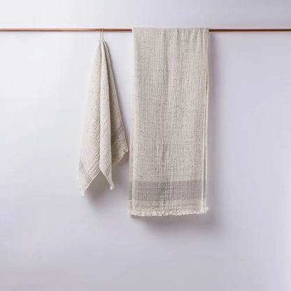 Two beige towels hanging together on a rod
