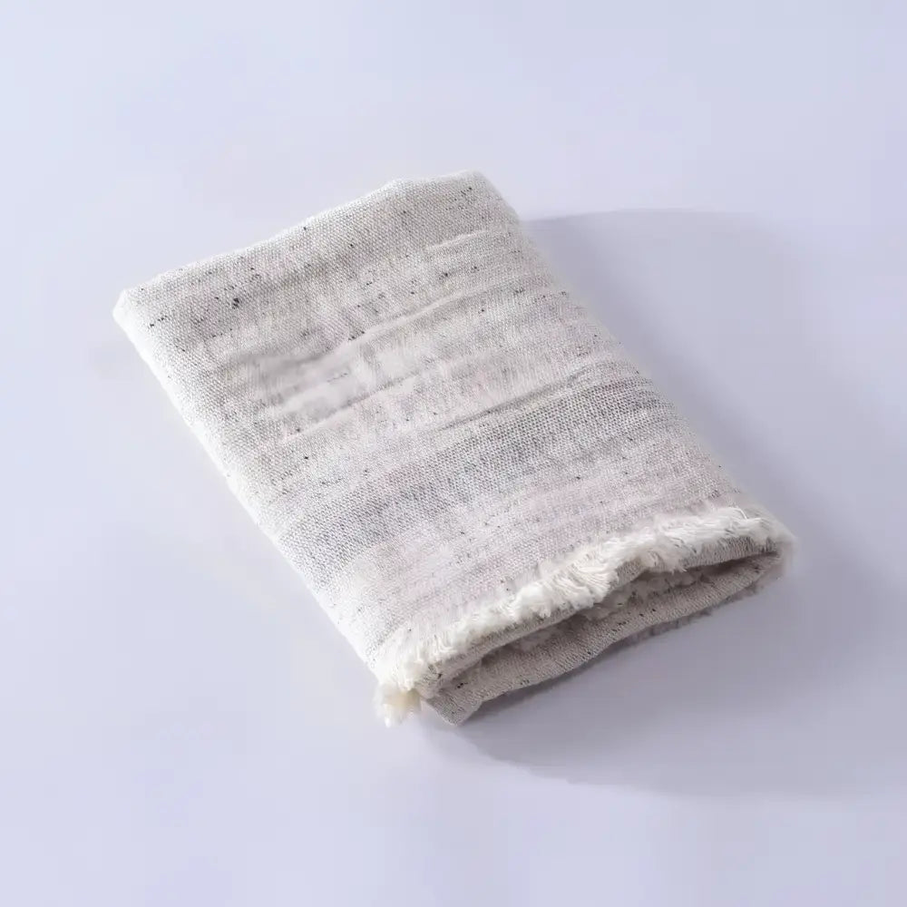 Folded textured towel on a light gray background