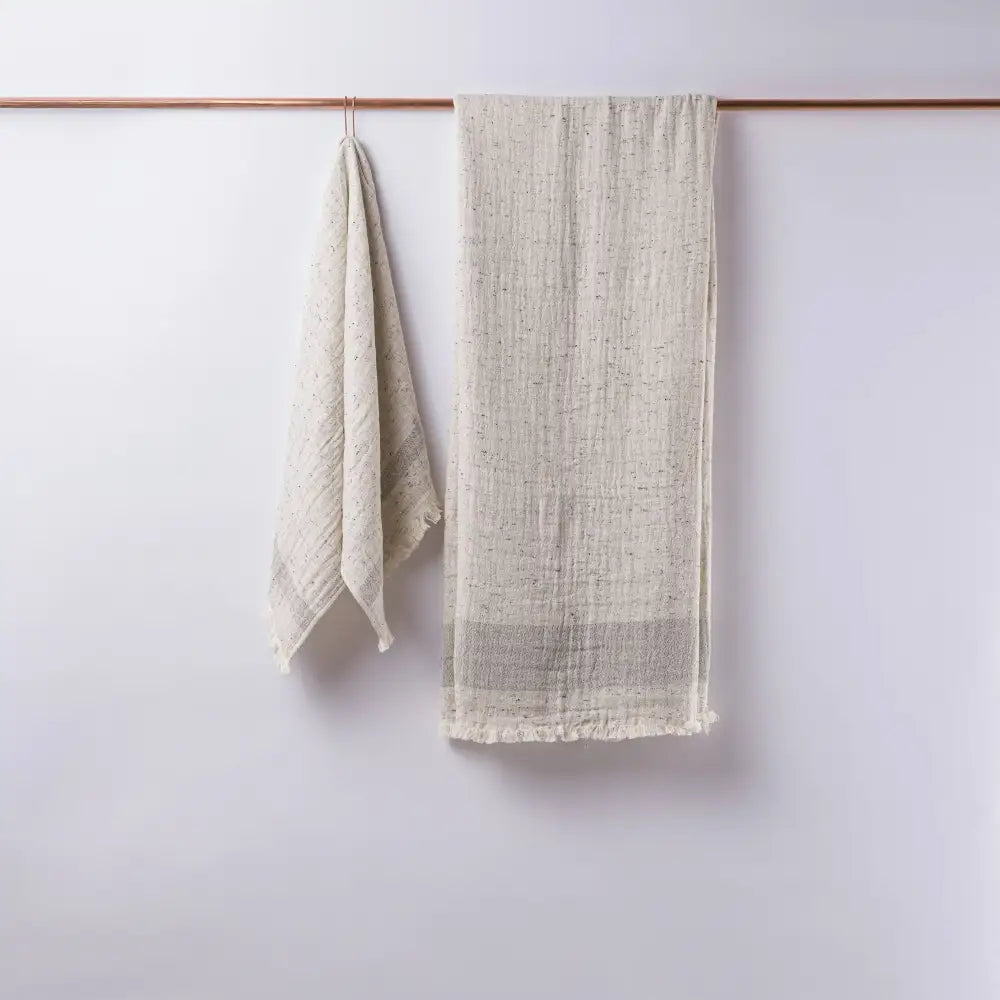 Light gray double-sided muslin hand towel with eyelash fringe ends. 