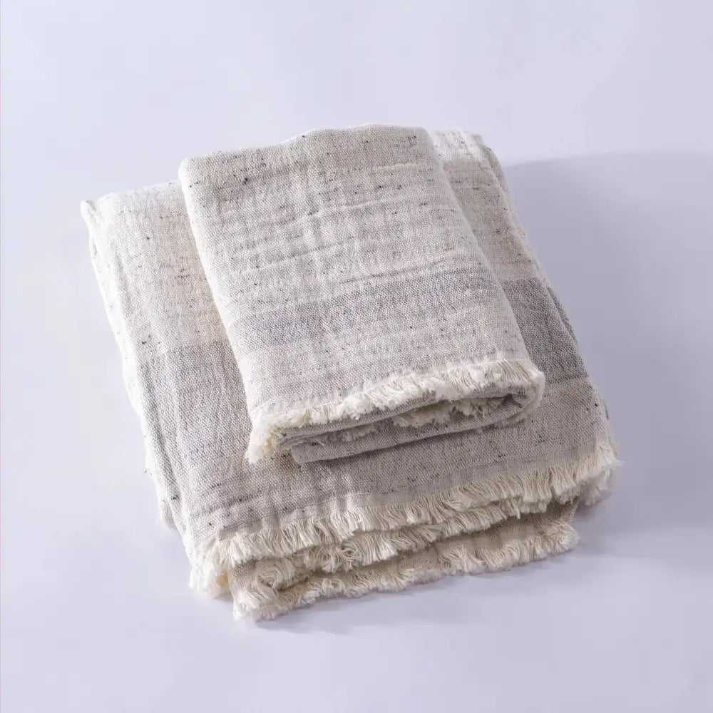 Light gray double-sided muslin hand towel with eyelash fringe ends. 