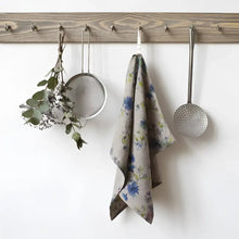 Natural linen kitchen towel with floral design, perfect for tackling spills in style