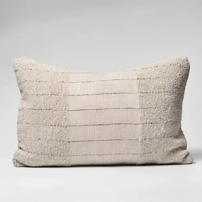 Textured pillow in natural color with black stripes.