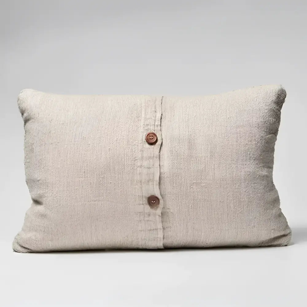 Textured pillow in natural color with black stripes and buttons on back side.