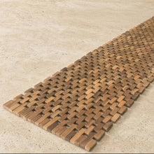 A rectangular woven natural teak table runner made from recycled teak pieces with interlocking slats in brown