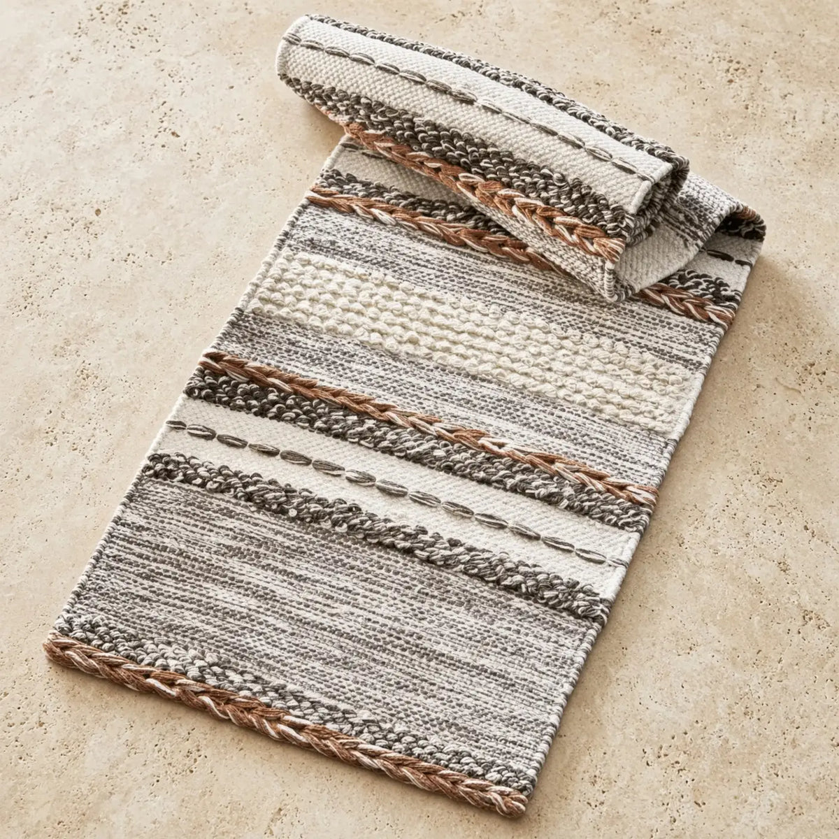 Natural textured table runner with handcrafted tassels and braided accents in beige gray and brown tones