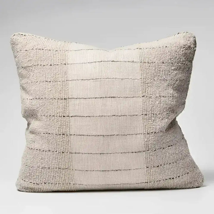 Textured pillow in natural color with black stripes.