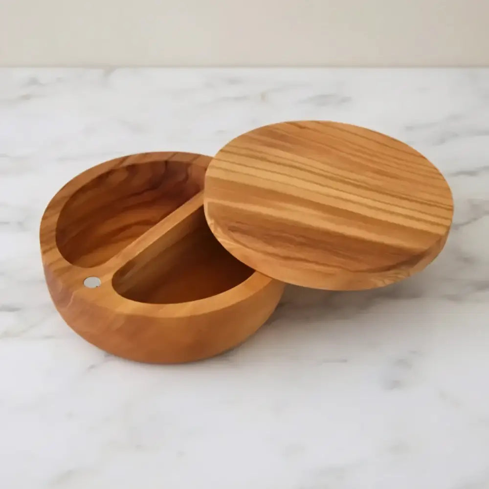 Round light brown olive wood dual compartment spice cellar with swiveling magnetic lid and natural wood grain finish