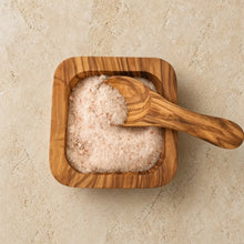 Square olive wood salt bowl with matching wood salt spoon filled with pink himalayan sea salt for spices and condiments