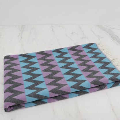 Folded organic bath towel with bold blue purple gray zigzag pattern perfect for beach use