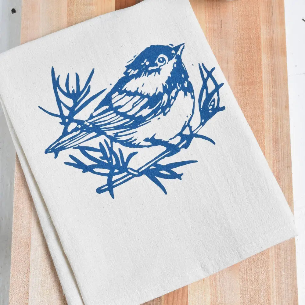  A white cloth napkin, hand-printed with an original Chickadee design in navy blue. 