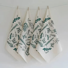 A set of four organic cloth napkins, hand-printed with an original Woodland Ferns design in green. 