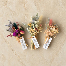 Three dried floral boutonnieres with colorful preserved flowers tied with twine labeled palo santo in flowers smudge stick set