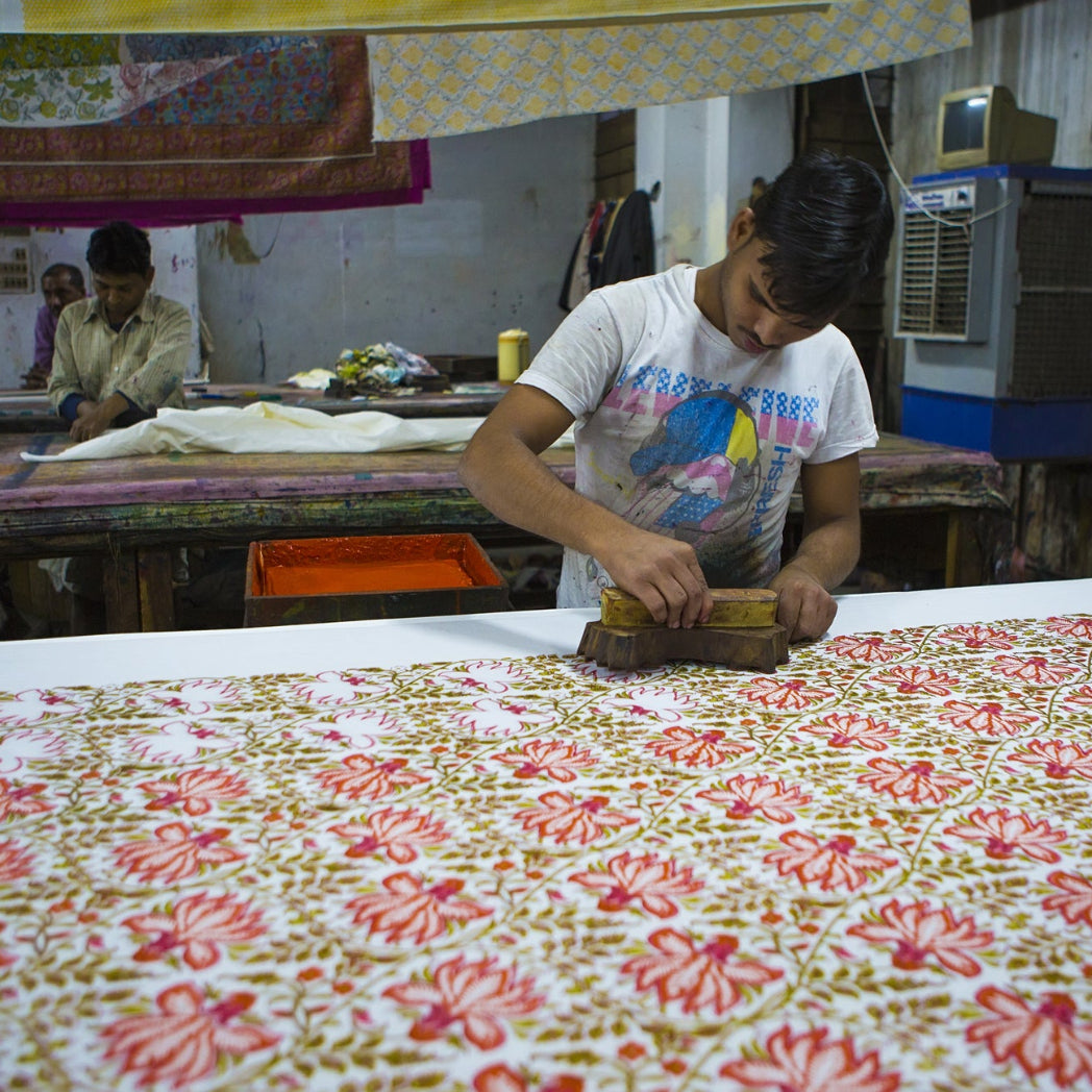 Person working on a floral fabric in a workshop setting