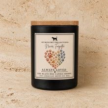 Black handmade soy candle with wooden lid featuring rainbow paw print heart and never forgotten label for pet sympathy