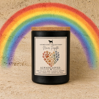 Black cylindrical handmade soy wax candle with wooden lid and rainbow paw print label from black dog candle shoppe