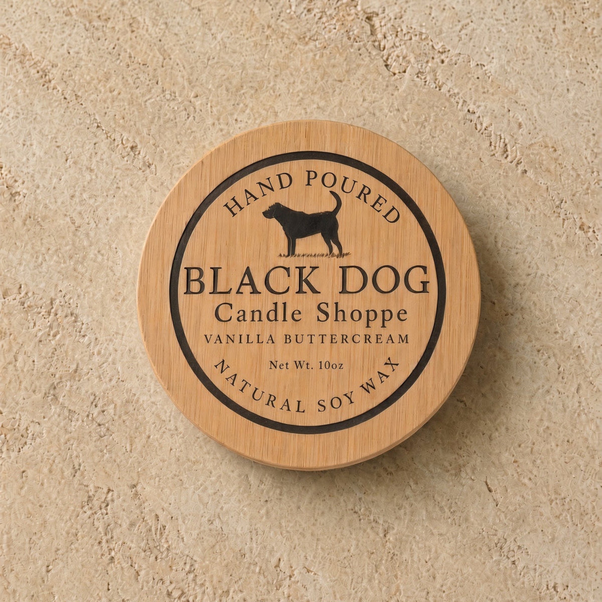 A round wooden lid with a black dog silhouette and engraved text for a handmade eco-friendly pet sympathy candle