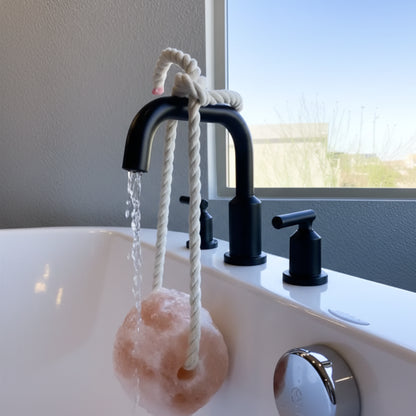 Pink Himalayan salt rock bath sponge on faucet
