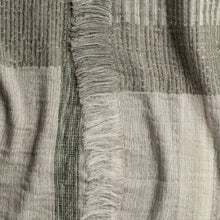 Gray and white striped scarf with frayed edges, perfect as a plaid throw blanket in soft ivory and sage green