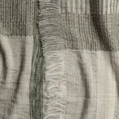 Gray and white striped scarf with frayed edges, perfect as a plaid throw blanket in soft ivory and sage green