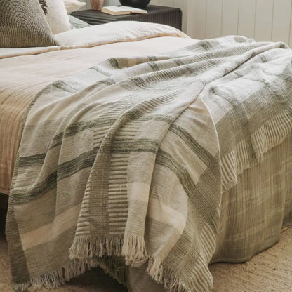 Plaid throw blanket in soft ivory and sage green with fringed edges, cozy and stylish