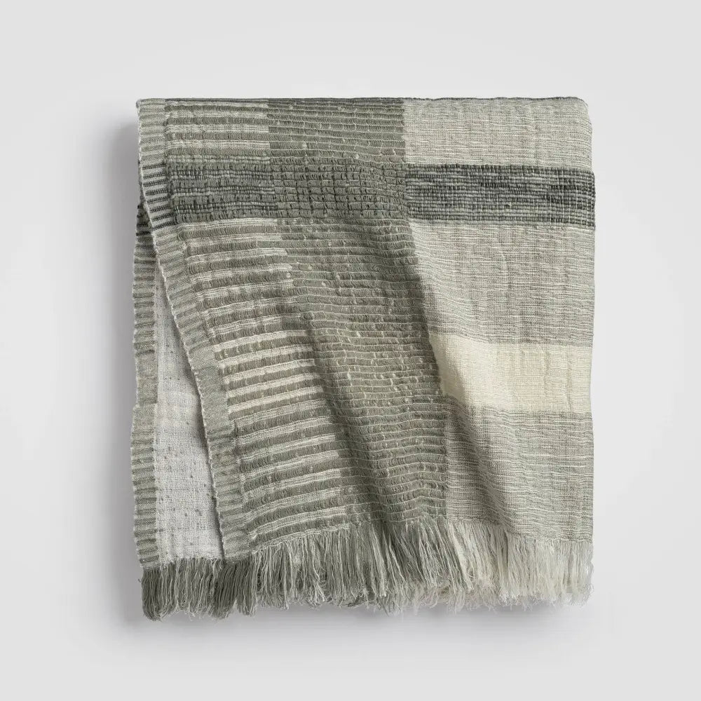 Gray and white plaid throw blanket in soft ivory and sage green with fringed edges