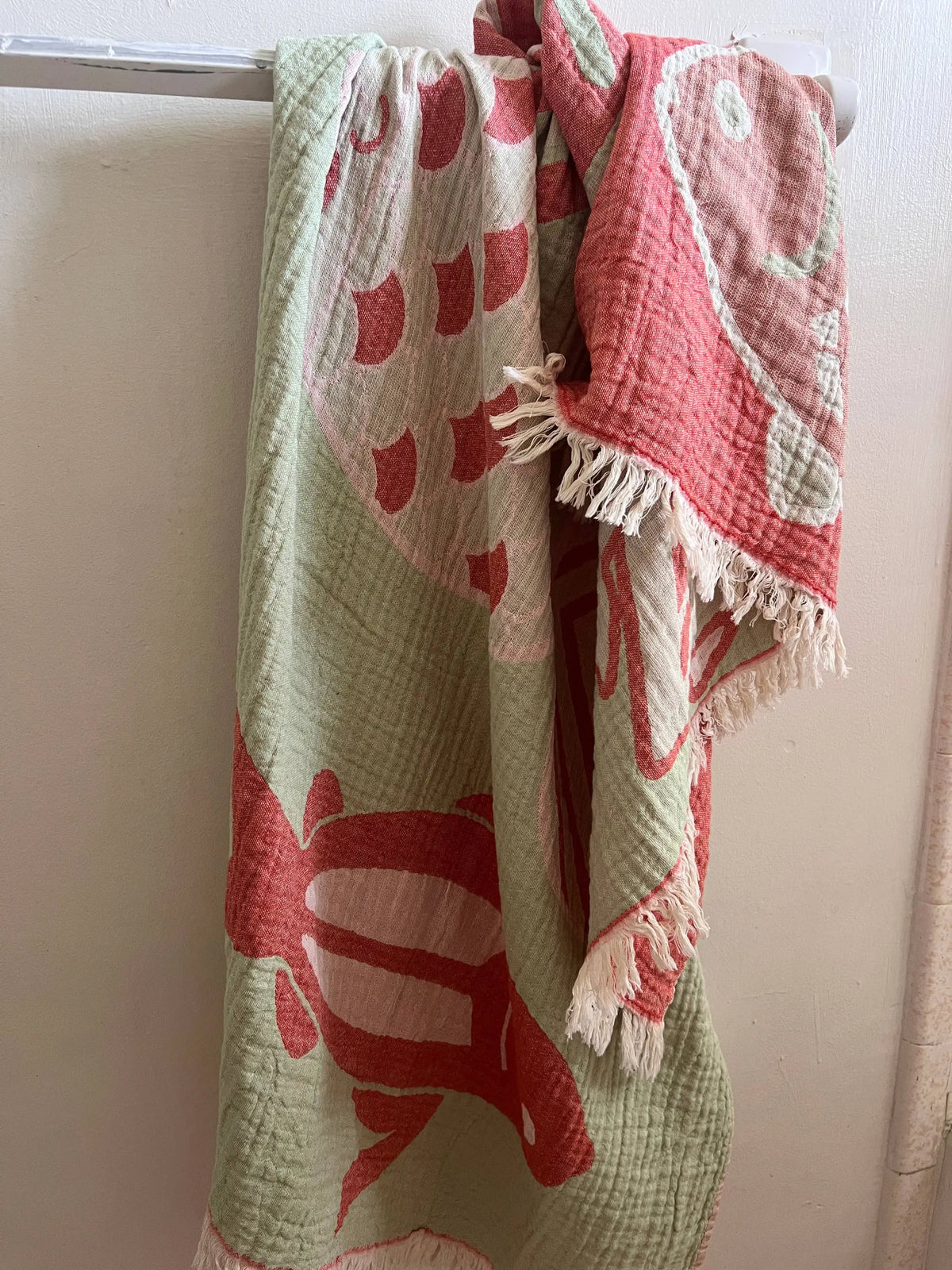 A turkish cotton harbor fish beach towel with pink and mint fish pattern white fringe edges sand repellent beach blanket