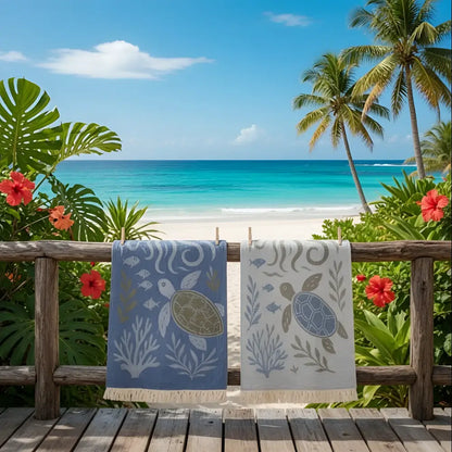 Two premium authentic turkish muslin beach towels in soft blue and off-white with sea turtle designs made of premium turkish cotton