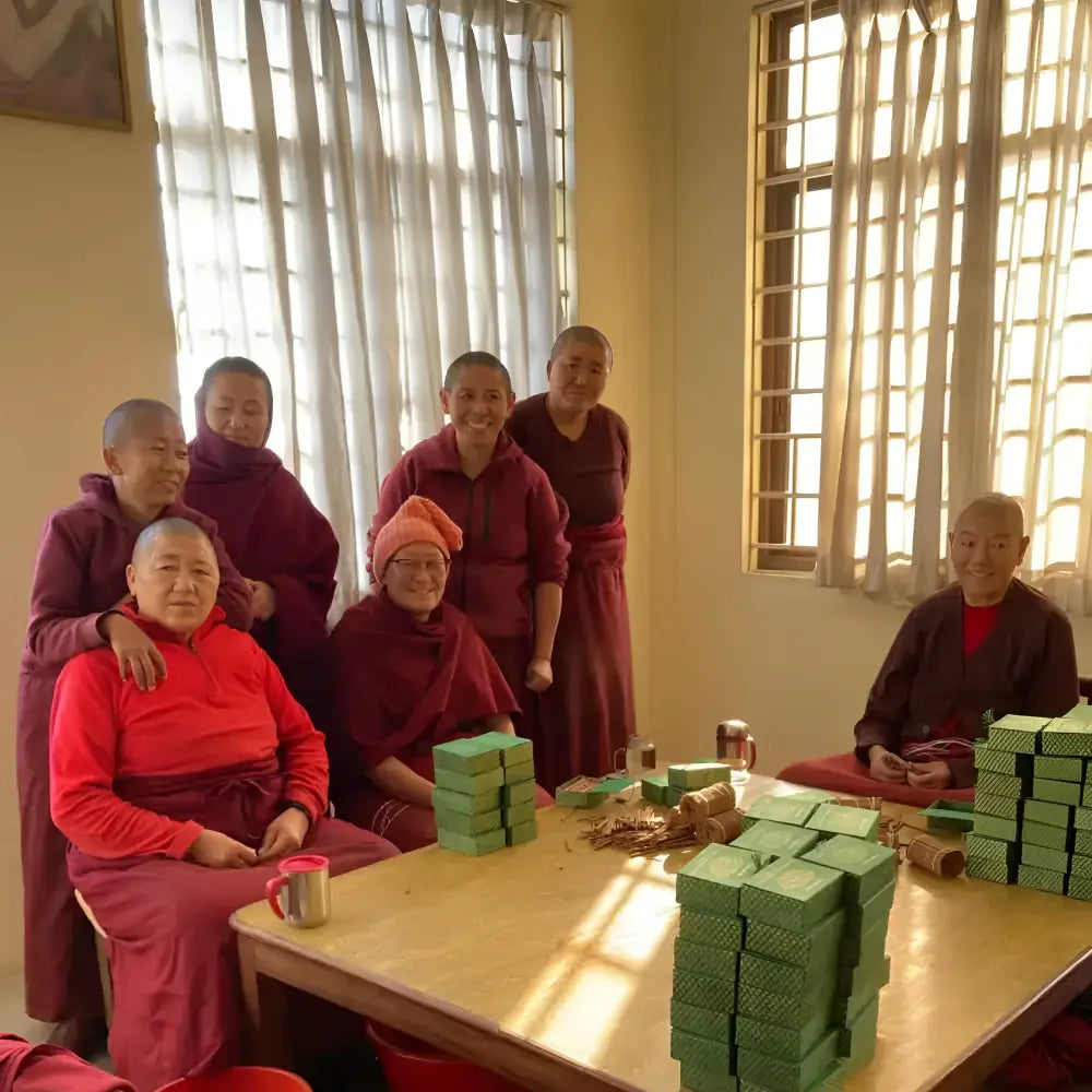 Stacks of green rectangular boxes of pure natural incense made by tibetan nuns from khachoe ghakyil ling nunnery on table
