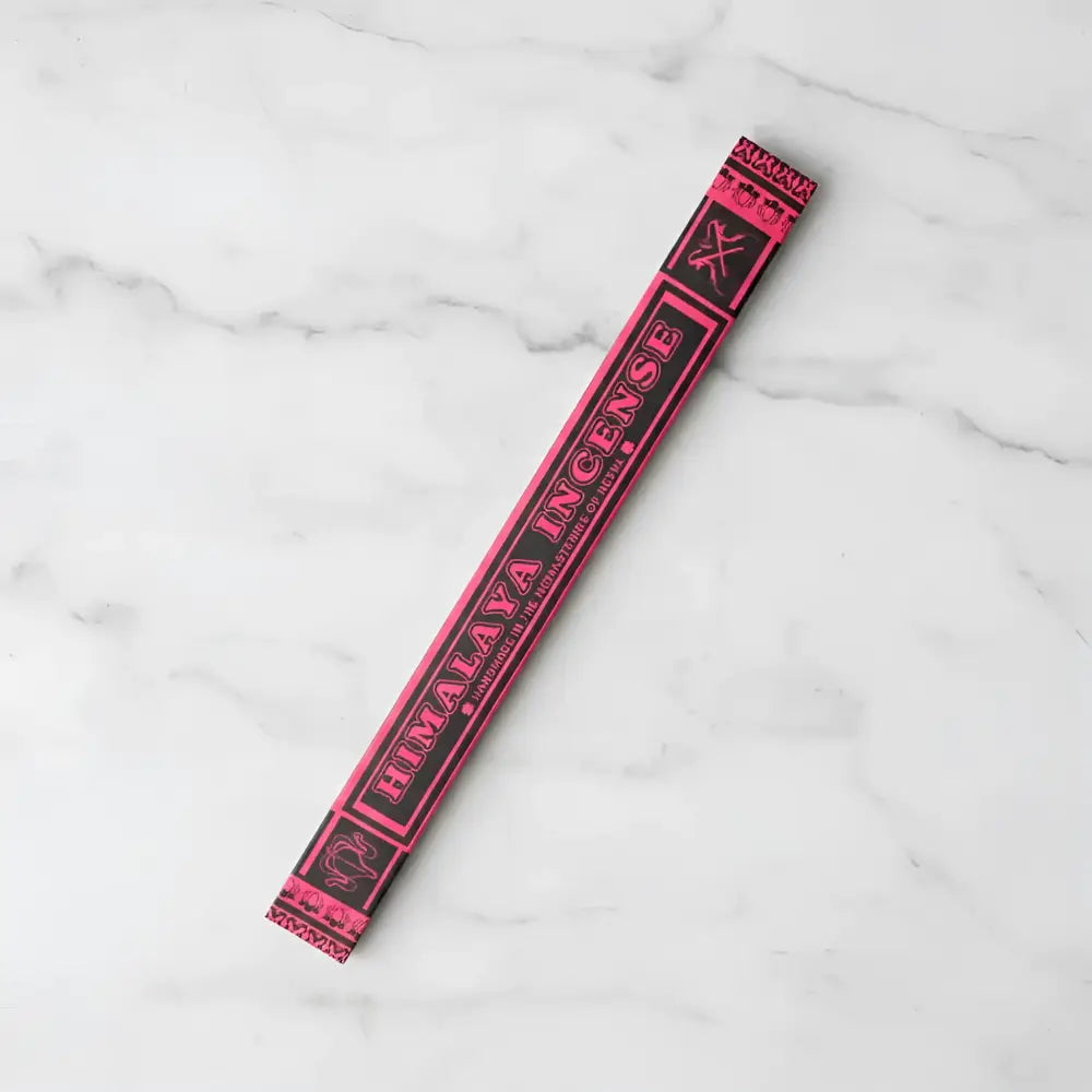 A vibrant pink and black himalaya incense stick package made by tibetan nuns from khachoe ghakyil ling nunnery