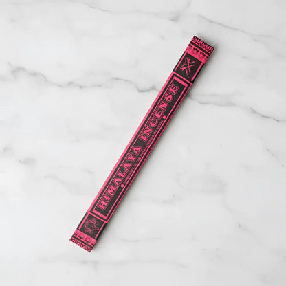 A vibrant pink and black himalaya incense stick package made by tibetan nuns from khachoe ghakyil ling nunnery