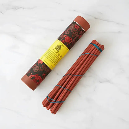 Red incense sticks bundled with blue string in a black and red tube by tibetan nuns from ghakyil ling nunnery