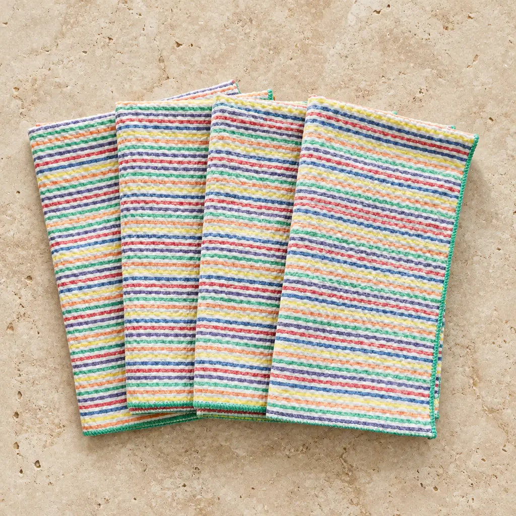 Set of four rainbow seersucker cloth napkins with vibrant multicolored horizontal stripes in a textured weave