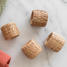 Natural woven rattan napkin rings set of four with a tight uniform weave and light tan color perfect for table settings