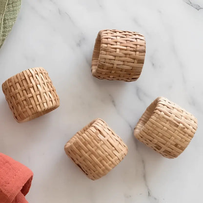 Natural woven rattan napkin rings set of four with a tight uniform weave and light tan color perfect for table settings