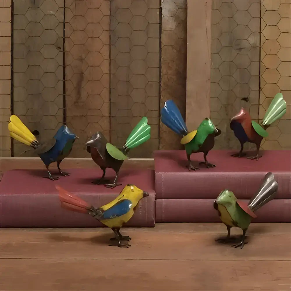 Colorful bird-shaped sculptures on a wooden surface with a patterned wall in the background