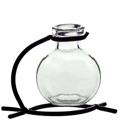 Recycled glass mini vase with black metal stand holding pink flowers