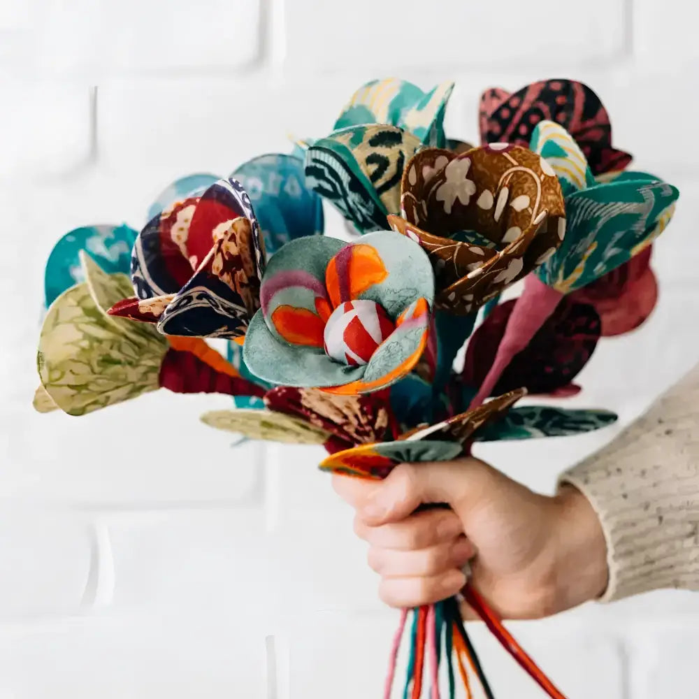 bouquet of flowers made from fabric in persons hand