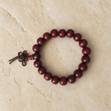 A dark red rosewood bracelet with plain 8mm beads and knotted cord perfect for essential oils use