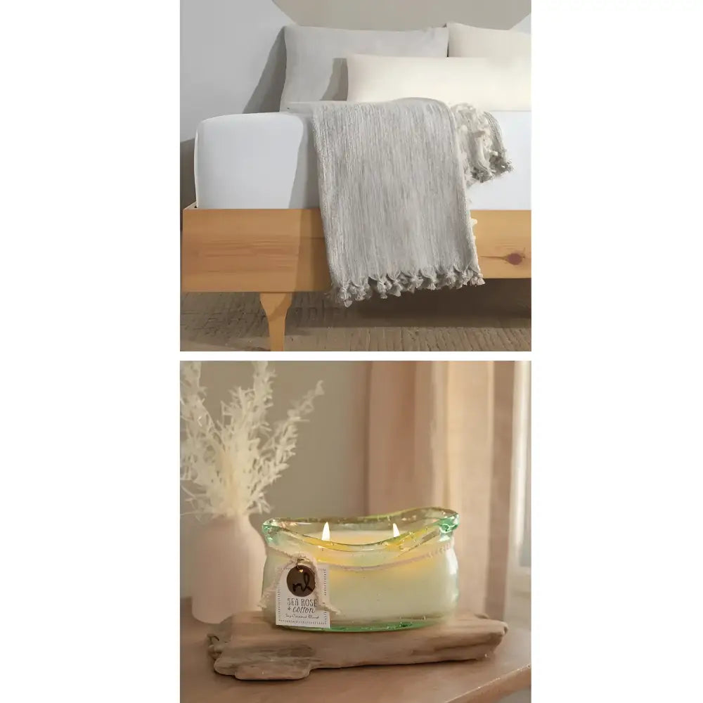 Bed with gray blanket and wooden headboard, candle on wooden surface